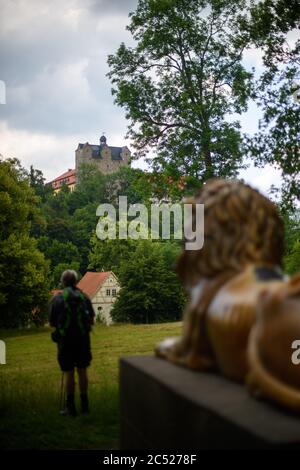 25 juin 2020, Saxe-Anhalt, Ballenstedt : le château de Ballenstedt surplombe le parc du château, qui est gardé par une sculpture de lion en fonte vieille de 200 ans de Gottfried Schadow. Le jardin du château est l'un des plus importants jardins de Saxe-Anhalt et couvre 29 hectares. Les terres remontent au prince Friedrich Albrecht d'Anhalt-Bernburg, qui a élevé Ballenstedt à sa résidence en 1765. Le château et le parc du château de Ballenstedt font partie du réseau « Garden Dreams - Historical Parks in Saxe-Anhalt » qui voulait célébrer son 20e anniversaire cette année. Il comprend 43 des plus importants et être Banque D'Images