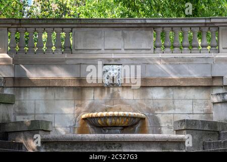 Fontaine de Lion en pierre près de l'entrée d'un beau parc. Colonnes de pierre en arrière-plan. Banque D'Images