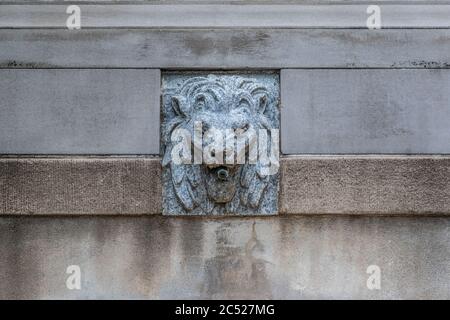 Fontaine de Lion en pierre près de l'entrée d'un beau parc. Colonnes de pierre en arrière-plan. Banque D'Images