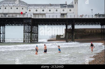 Brighton UK 30 juin 2020 - les baigneurs de mer bravent les conditions à Brighton lors d'une journée humide et venteuse par rapport à cette fois la semaine dernière, quand la vague de chaleur d'été commençait avec des températures supérieures à 30 degrés : Credit Simon Dack / Alay Live News Banque D'Images