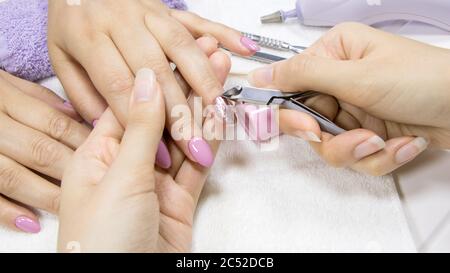 Manucure. Retrait des cuticules avec l'outil à ongles Professional, pinces à métaux. Manucure beauté. Manucure dans un salon de beauté. Spa, soins des ongles, voiture de peau Banque D'Images