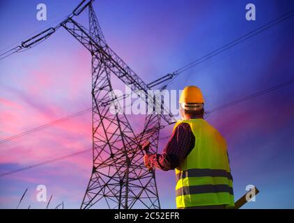 Effectuer un entretien technique pendant l'inspection de la ligne électrique. Électricien au travail. Production et fourniture d'énergie à partir de centrales électriques. Banque D'Images