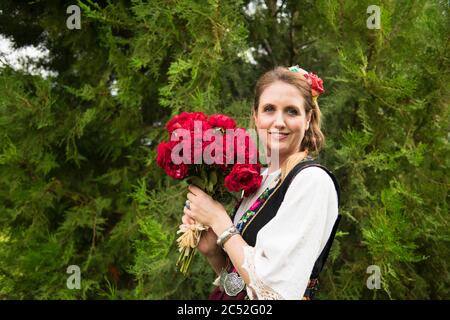 Femme debout dans un jardin portant un costume bulgare traditionnel, Bulgarie Banque D'Images