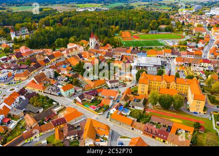 Vue panoramique depuis drone de l'ancien centre-ville de Blatna avec toits rouges de maisons, tour gothique de cloche et château d'eau, quartier Strakonice, République tchèque Banque D'Images