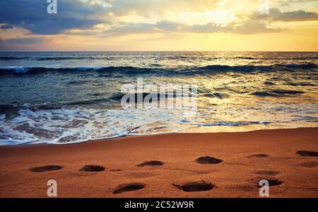 Empreintes sur une plage tropicale au coucher du soleil, foyer sélectif, Sri Lanka. Banque D'Images