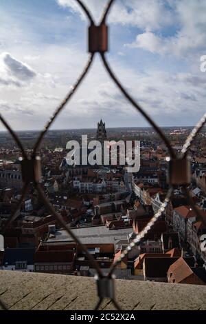 Vue panoramique sur la vieille ville de Bruges, Belgique. Photo prise à travers le filet de clôture du clocher, mise au point sélective. Banque D'Images