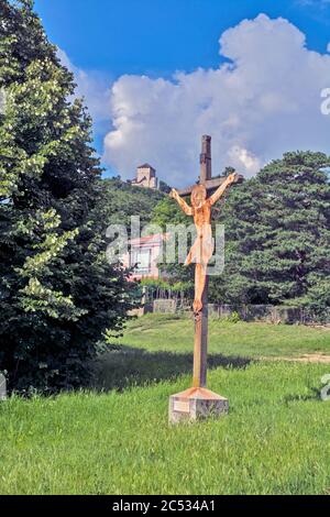 Un symbole de la crucifixion de Jésus sur un pilier et une ancienne forteresse médiévale en arrière-plan. Banque D'Images