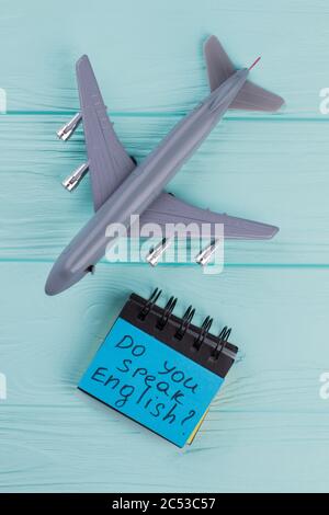 Jouet en plastique avion à réaction passager et papier adhésif sur fond bleu en bois. Banque D'Images