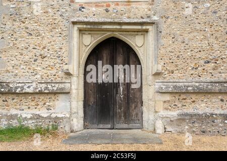 Très ancienne porte en bois voûté avec mur en pierre. Hunsdon, Hertfordshire. ROYAUME-UNI Banque D'Images
