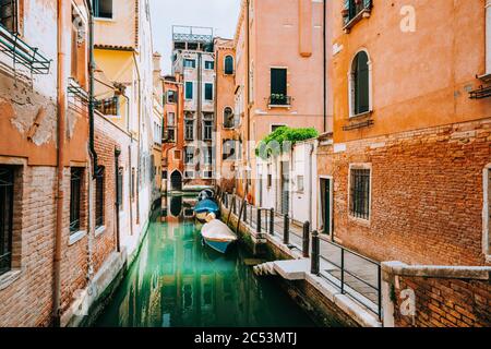 Venise Italie. Canal avec maisons anciennes à façade orange typique, patio et fenêtres. Banque D'Images