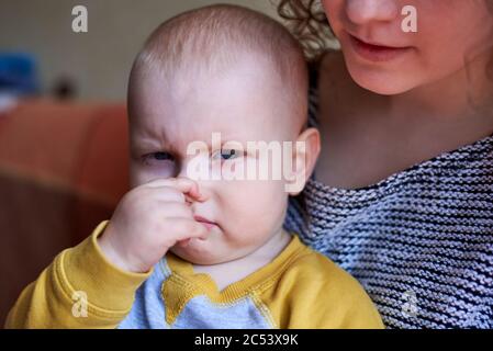 Petit drôle mignon garçon avec le doigt dans le nez Banque D'Images