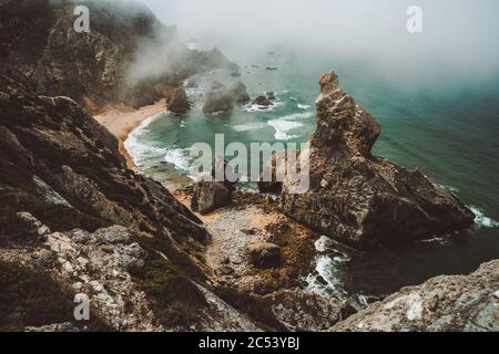 Sentra, Portugal. Un temps brumeux et de mauvaise humeur à la plage de Praia da Ursa le matin. Océan Atlantique. Banque D'Images