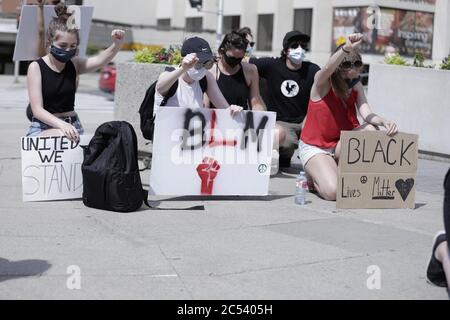 Un groupe de manifestants s'agenouille avec des affiches en l'honneur de la matière de la vie noire BLM Banque D'Images