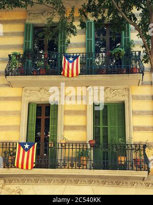Drapeaux catalans accrochés sur les balcons d'un bâtiment à Barcelone. Banque D'Images