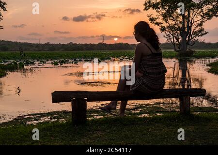 Jeune femme au coucher du soleil sur le lac au Sri Lanka Banque D'Images