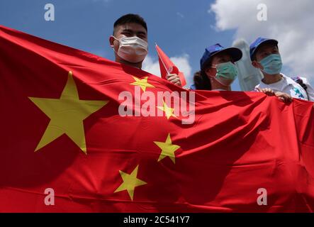 Hong Kong, Chine. 30 juin 2020. Les partisans de Pékin se posent avec les drapeaux nationaux de la Chine lors d'un rassemblement pour célébrer l'adoption d'une loi sur la sécurité nationale le 30 juin 2020 à Hong Kong, Chine. Beijing a adopté la loi controversée sur la sécurité nationale qui menacera les villes autonomie et libertés politiques crédit: May James/ZUMA Wire/Alamy Live News Banque D'Images