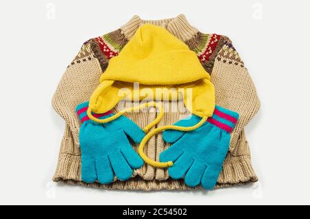 Ensemble de vêtements tricotés pour enfants composés de chapeaux, chandails et gants isolés sur un fond blanc Banque D'Images