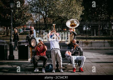 Cinq musiciens de jazz du sud produisent une chanson sur un banc de parc à l'extérieur de Jackson Square dans le quartier français de New Orlean Banque D'Images