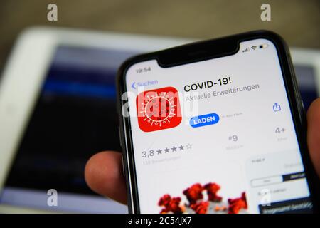 Viersen, Allemagne - juin 30. 2020 : gros plan de l'écran du téléphone portable maintenez la main d'un homme avec l'application d'avertissement Covid-19 de la boutique de téléchargement (en mettant l'accent sur le symbole rouge Banque D'Images