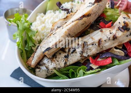 poulet grillé en priorité sur une salade avec du fromage et des tortillas multicolores Banque D'Images