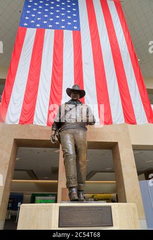 Une statue de John Wayne, grande et très célèbre, avec un drapeau américain en arrière-plan à l'aéroport John Wayne. Santa Ana.Orange County.California.USA Banque D'Images