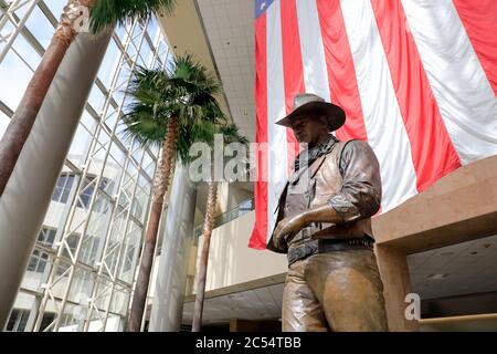 Une statue de John Wayne, grande et très célèbre, avec un drapeau américain en arrière-plan à l'aéroport John Wayne. Santa Ana.Orange County.California.USA Banque D'Images