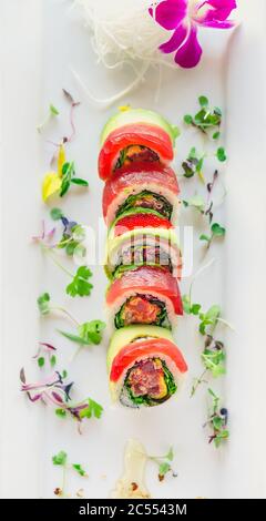 Vue sur le plateau du sushi Maki au thon. Un rouleau de sushi de style uramaki sur une assiette blanche. Le thon sashimi cru et le riz sont à l'extérieur tandis que le nori est à l'intérieur. Ceci Banque D'Images