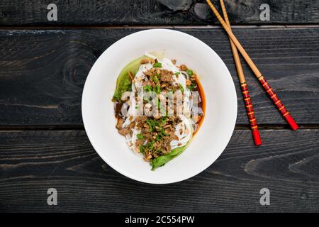 Vue de dessus de Dan Noodles. DaN Dan Noodles est un plat épicé de cuisine de Szechuan que l'on trouve couramment dans la cuisine chinoise de rue. Les ingrédients comprennent des nouilles de riz épaisses Banque D'Images