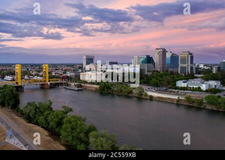 Vue aérienne d'un ciel rose au coucher du soleil sur le centre-ville de Sacramento, la rivière et le Tower Bridge de couleur or Banque D'Images