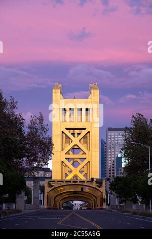 Coucher de soleil rose derrière le pont Golden Tower Bridge qui traverse la rivière Sacramento et mène au centre-ville Banque D'Images