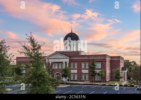 Des nuages colorés au coucher du soleil s'élèvent au-dessus de l'hôtel de ville et du palais de justice de Snellville, en Géorgie, juste à l'extérieur d'Atlanta. (ÉTATS-UNIS) Banque D'Images