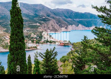 Péninsule de Frourio et village d'Assos avec une baie de mer magnifique et des cyprès en premier plan. Île de Kefalonia, Grèce. Banque D'Images