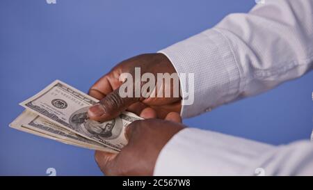Mains d'un homme d'Afrique Noire comptant de l'argent - dollars US billets de monnaie. Épargne et hypothèque Banque D'Images