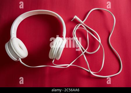 Prise de vue en grand angle d'un casque filaire blanc sur un rouge surface Banque D'Images
