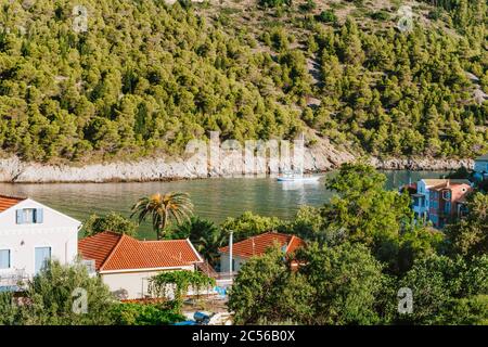 Yacht blanc dans une belle crique de mer du village d'Assos sur l'île de Céphalonie. Grèce. Banque D'Images