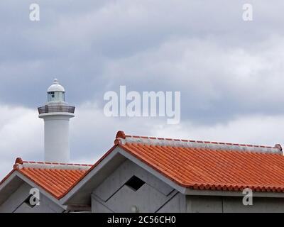 Le phare du cap Zanpa et ses bâtiments de toit en tuiles rouges sur une journée nuageux à Okinawa, au Japon Banque D'Images