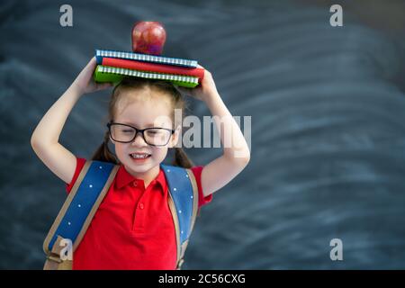 Retour à l'école! Heureux mignon enfant industriel apprend en classe sur fond de tableau noir. Banque D'Images