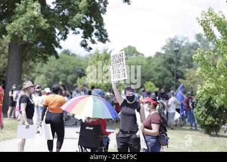 Un manifestant dans la foule tient un signe disant de définancer, de désarmer, de démanteler la police Banque D'Images