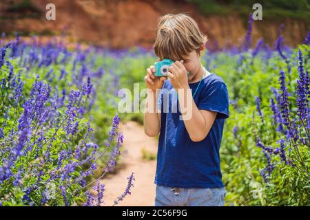 Petit photographe prenant des photos avec un appareil photo jouet Banque D'Images