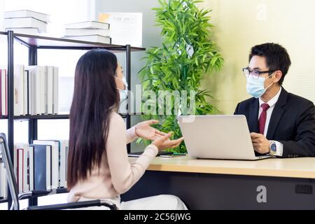 Portrait d'un conseiller d'affaires asiatique donnant des conseils au client sur la situation de prêt financier dans le bureau de banque. Nouvelle entreprise de distance sociale normale pour ba Banque D'Images