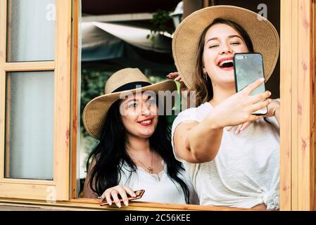 Les jolies jeunes filles à l'envie ont beaucoup de plaisir ensemble dans l'amitié prenant l'image selfie avec le grand téléphone cellulaire moderne à partager sur les médias sociaux - infleu Banque D'Images