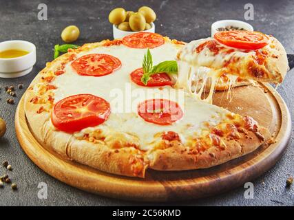 Le goût délicieux de pizza et de tranches de fromage avec mozzarella et tomates. Pizza triangle avec fromage et épices. Banque D'Images
