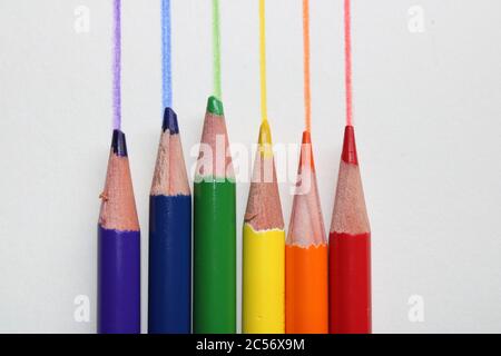 Crayons de couleur dans l'ordre spectral arc-en-ciel par rapport aux lignes dessinées correspondantes Banque D'Images