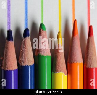 Crayons de couleur dans l'ordre spectral arc-en-ciel par rapport aux lignes dessinées correspondantes Banque D'Images