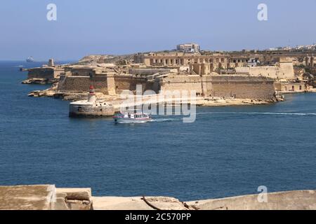 La Valette. Malte. Vieux phare rouge à Grand Harbour et pont brise-lames, fort Ricasoli à Kalkara à côté de la Valette. Banque D'Images