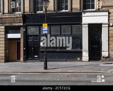 Vide parking et boutique dans le centre-ville de Newcastle uon Tyne avec un panneau de signalisation indiquant les restrictions de stationnement. Banque D'Images