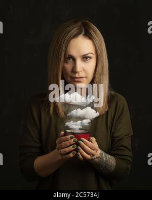 Portrait femme tenant une tasse de café avec des nuages Banque D'Images