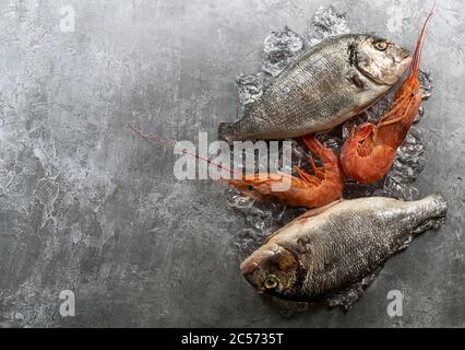 Poissons et crevettes dorado frais crus sur les glaçons. Banque D'Images