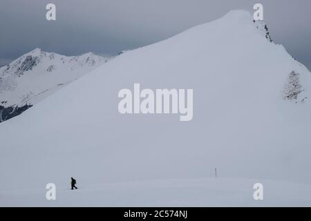 Homme raquette sous la montagne enneigée, Davos, canton de Graubuenden, Suisse Banque D'Images