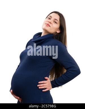 Femme enceinte posant dans la robe bleue à col roulé isolée sur fond blanc comme concept de confiance Banque D'Images